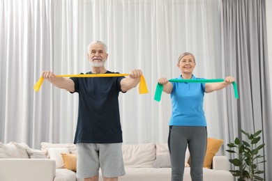 Senior couple doing exercise with fitness elastic bands at home