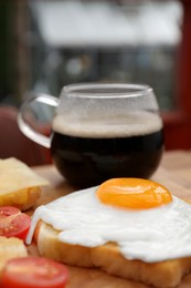 Tasty toasts with fried egg on wooden table, closeup