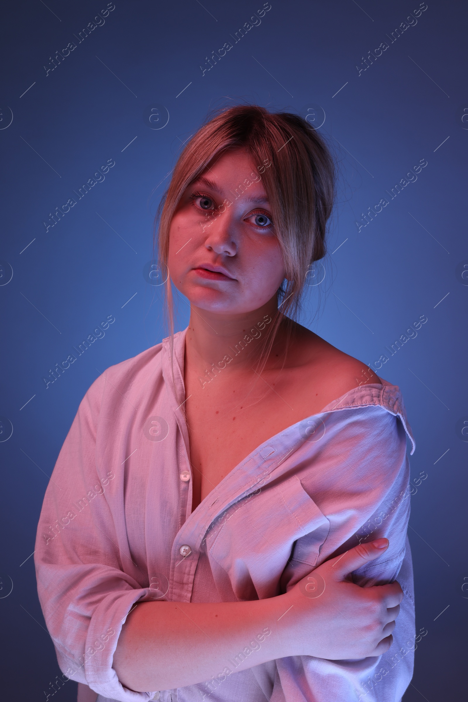 Photo of Portrait of beautiful young woman on color background with neon lights