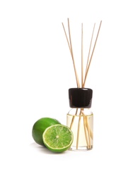 Photo of Aromatic reed air freshener and lime on white background