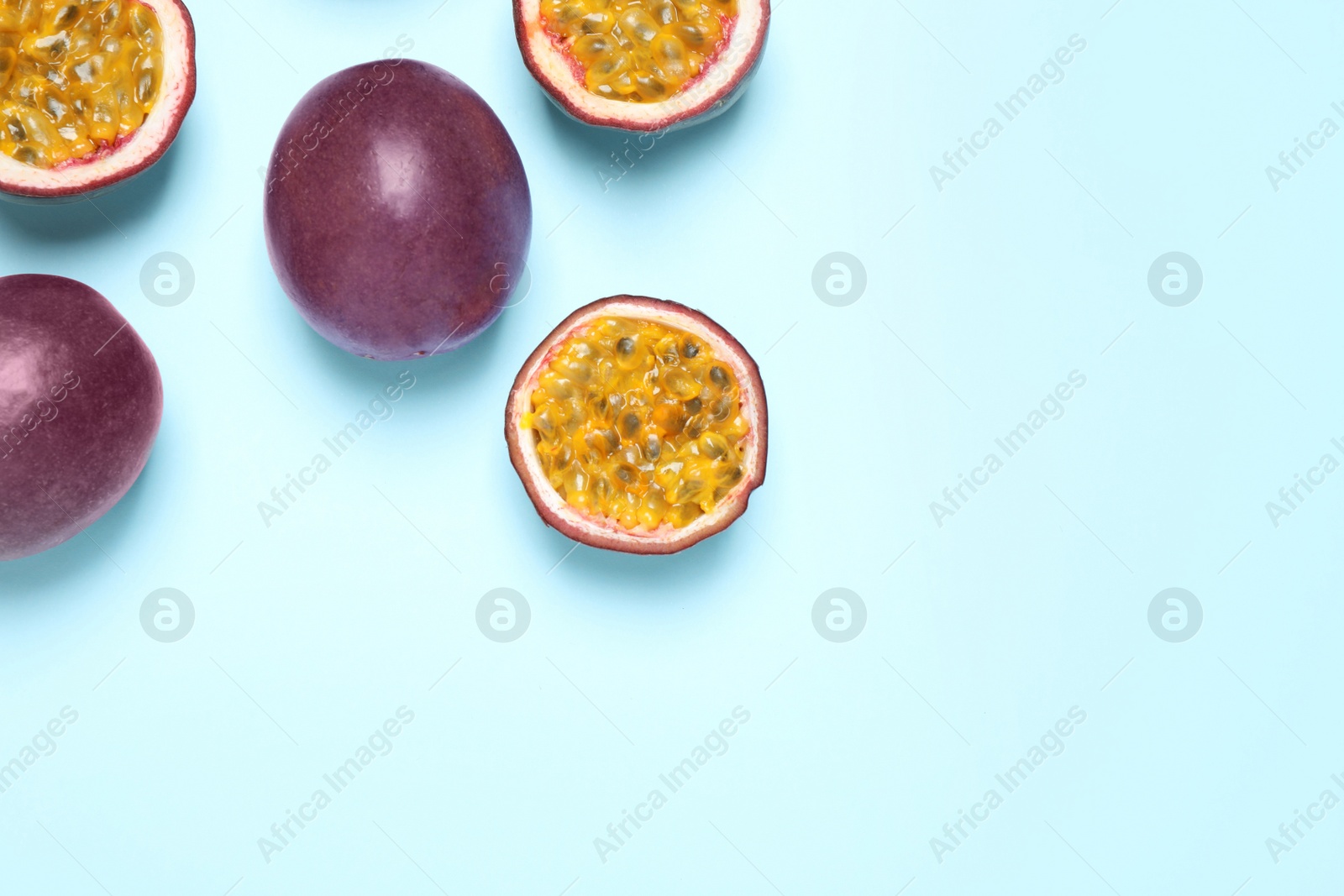 Photo of Fresh ripe passion fruits (maracuyas) on light background, flat lay. Space for text