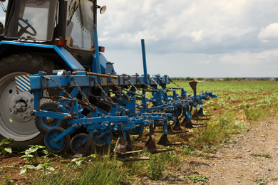 Photo of Tractor in field, closeup view. Agricultural industry