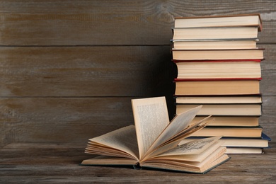 Photo of Stack of hardcover books on wooden table. Space for text