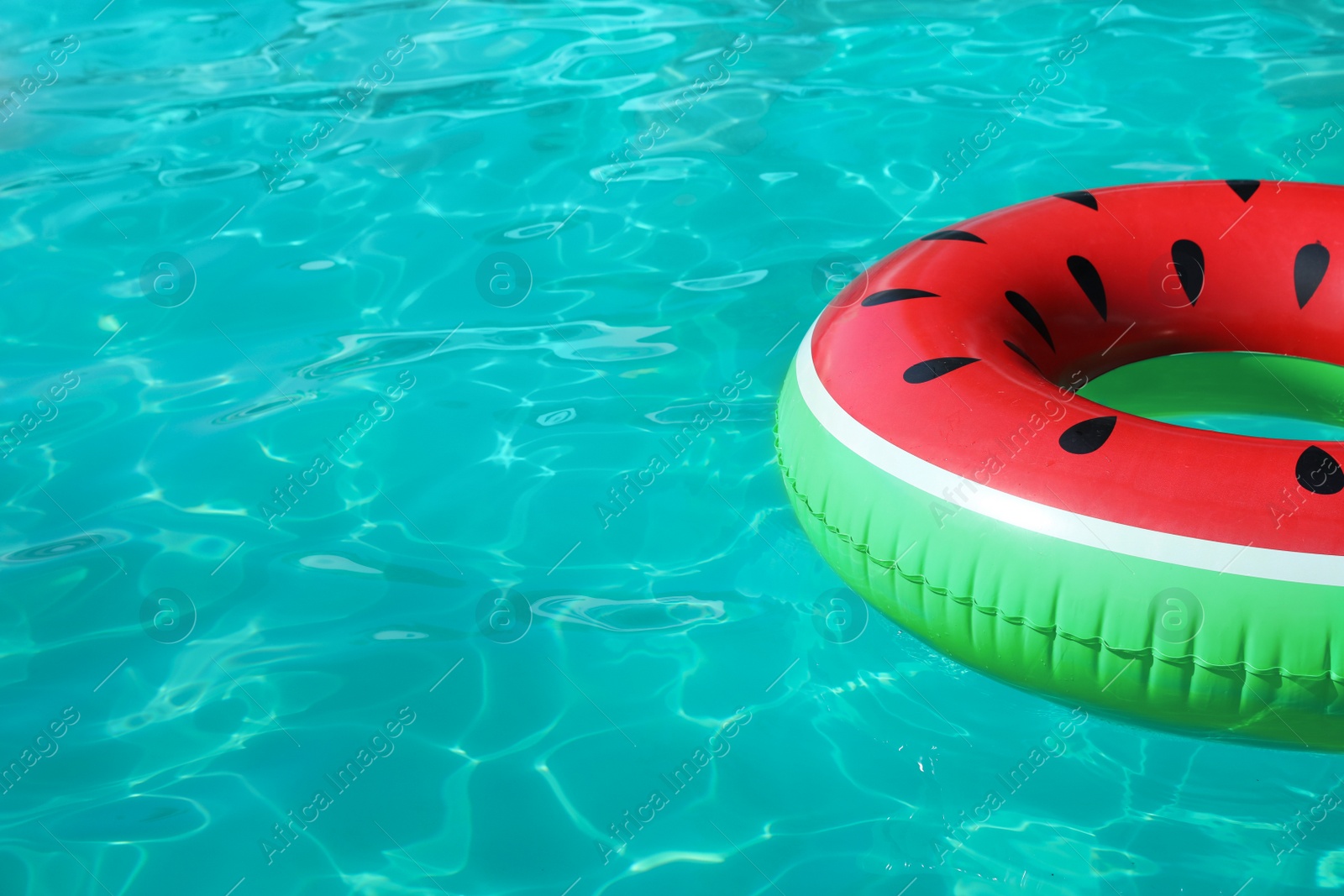 Photo of Inflatable ring floating in swimming pool on sunny day. Space for text