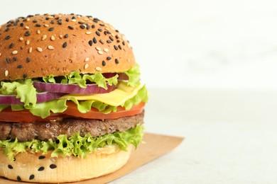 Photo of Burger with delicious patty on light table, closeup. Space for text