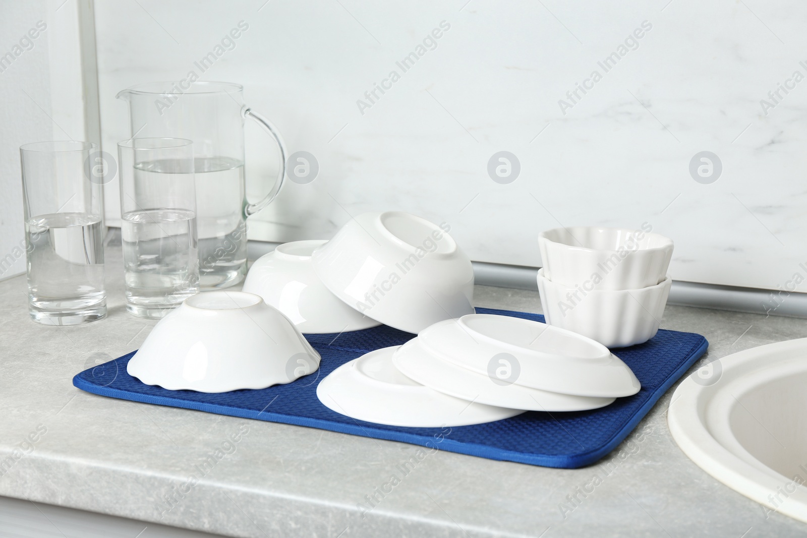 Photo of Different clean plates near sink in kitchen