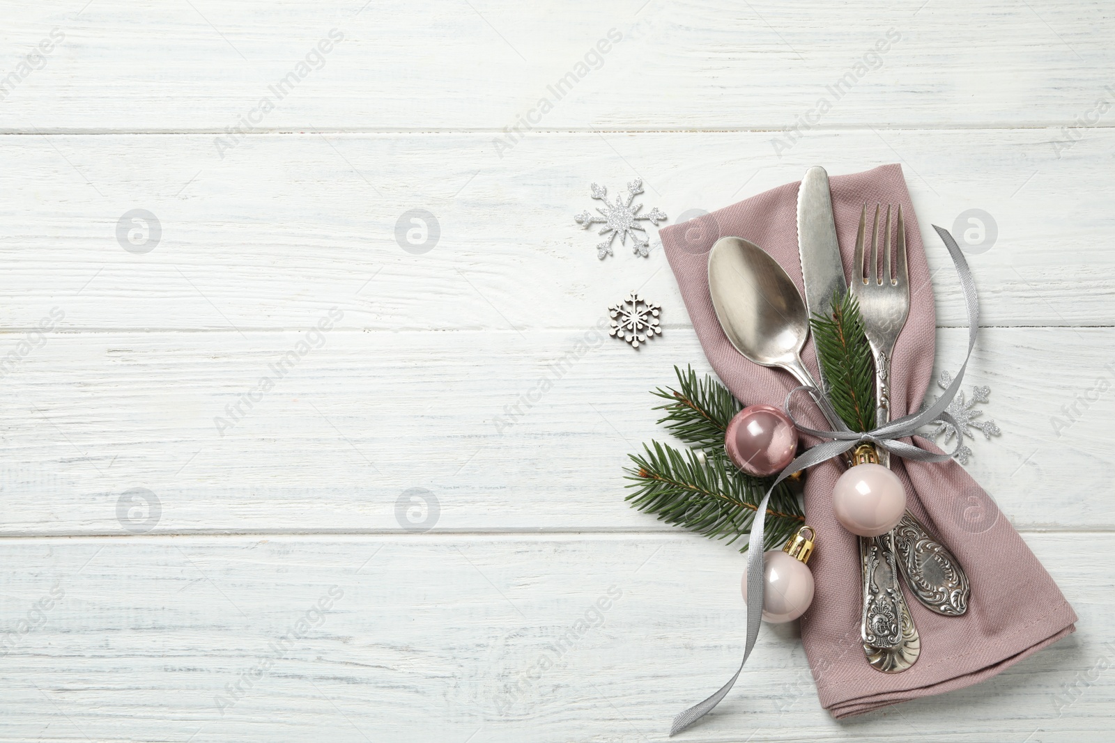 Photo of Cutlery set and festive decor on white wooden table, flat lay with space for text. Christmas celebration