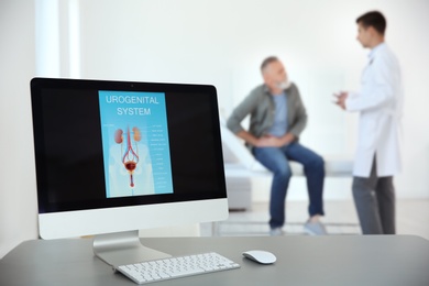 Photo of Computer monitor with picture of urogenital system and blurred people on background