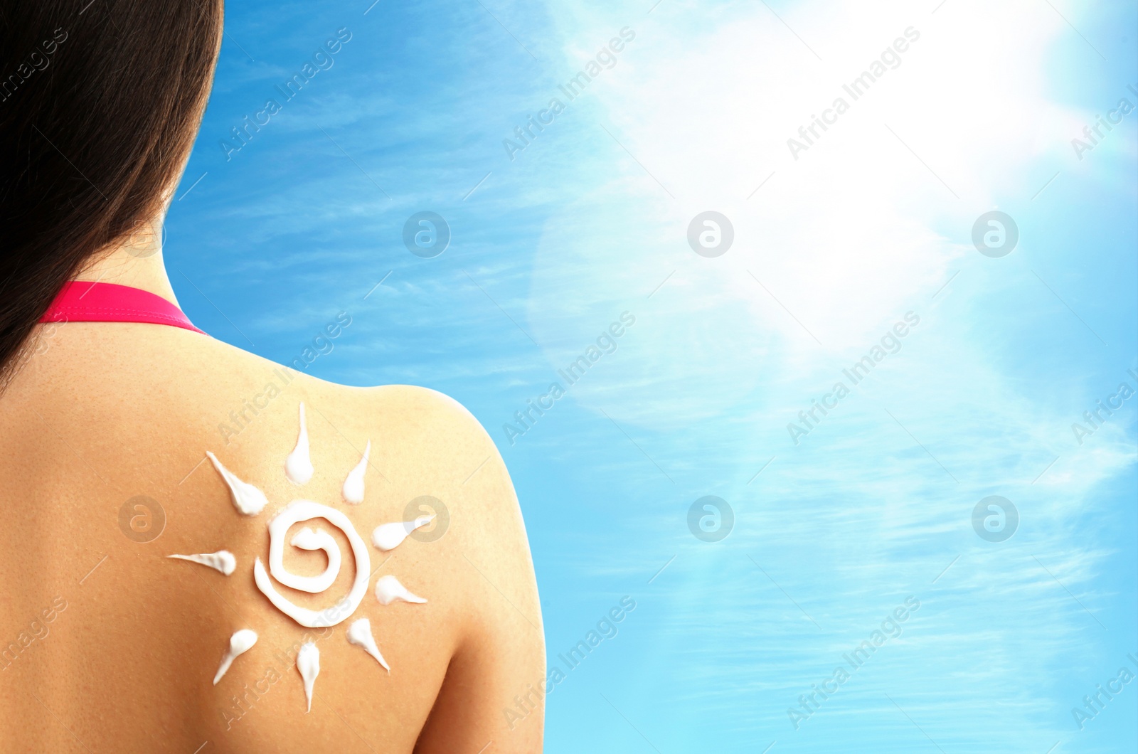 Image of Young woman with sun protection cream on her back outdoors, closeup. Space for text