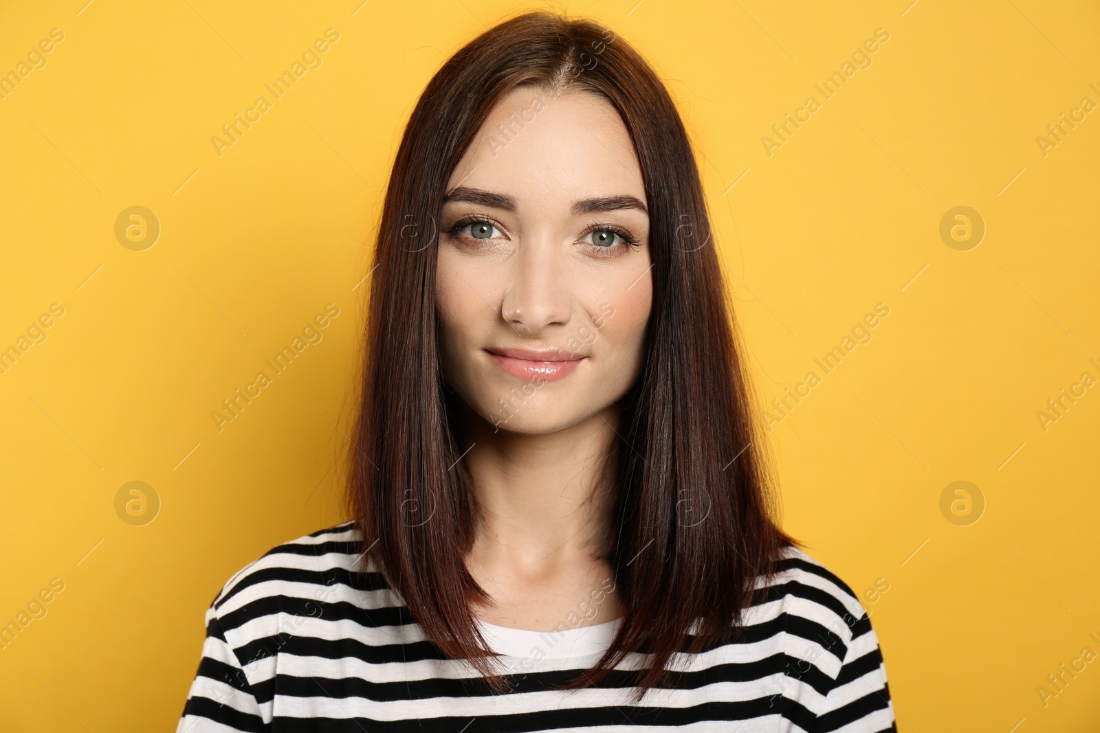 Photo of Portrait of pretty young woman with gorgeous chestnut hair on yellow background
