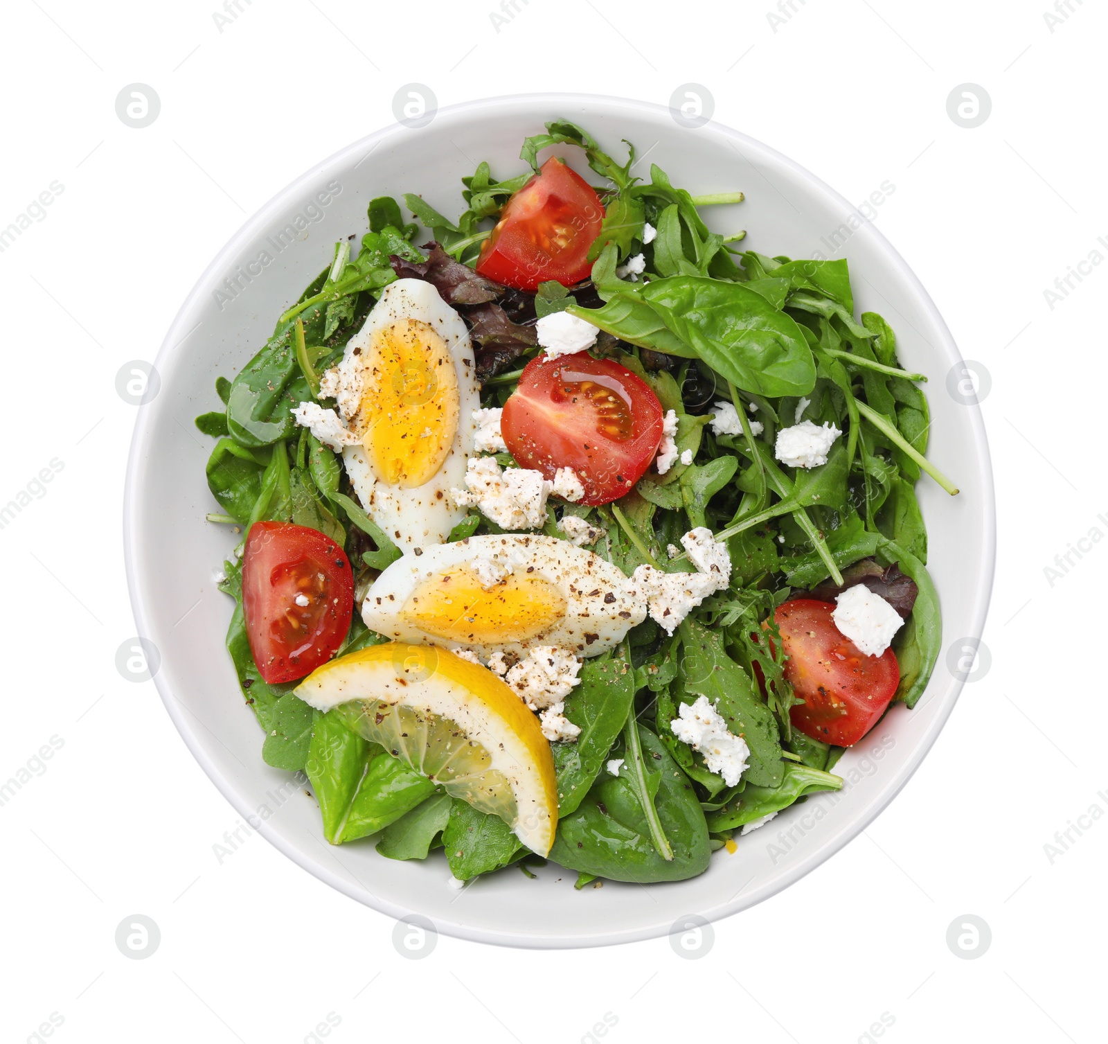 Photo of Delicious salad with boiled egg, tomatoes and cheese in bowl isolated on white, top view