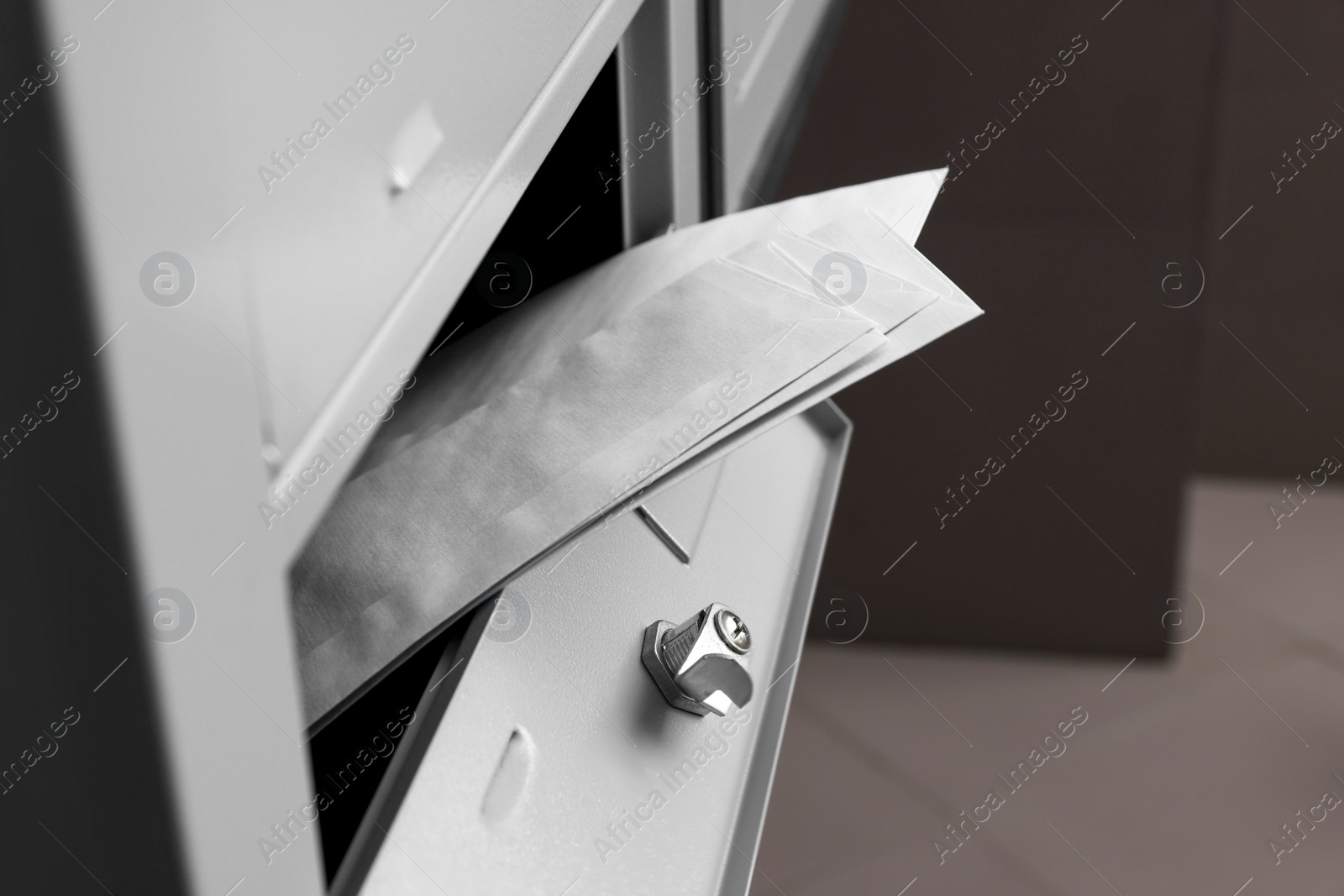 Photo of Open metal mailbox with envelopes indoors, closeup view