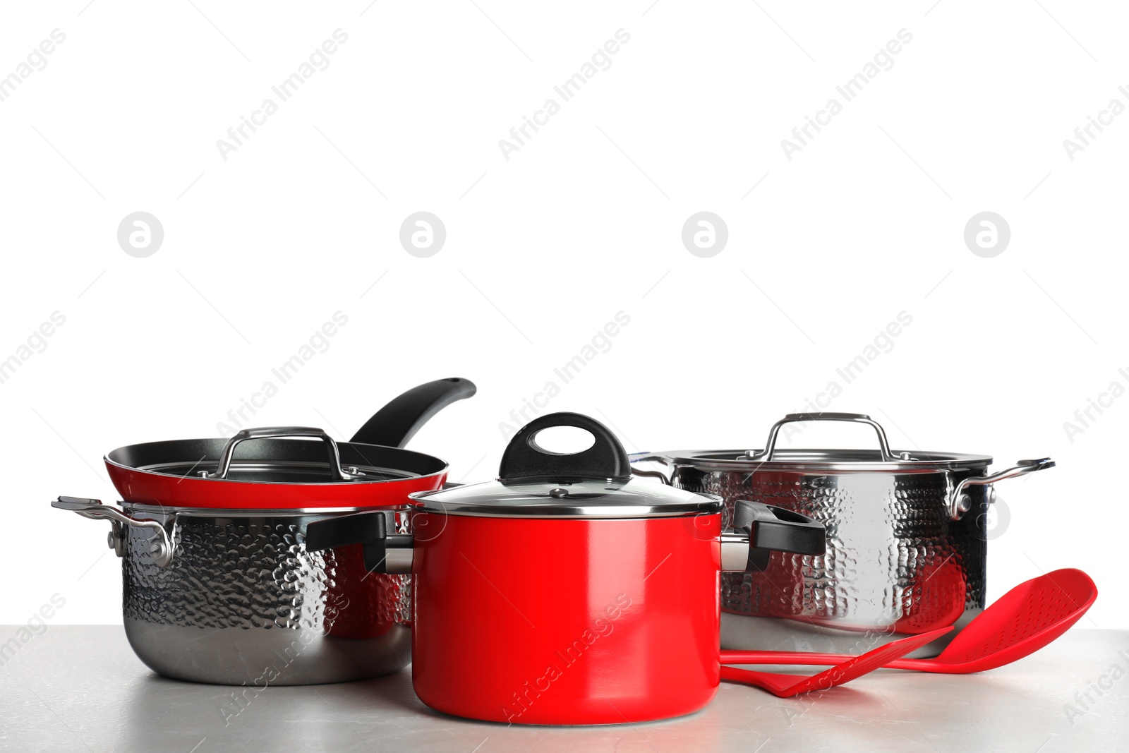 Photo of Set of clean cookware and utensils on table against white background, space for text
