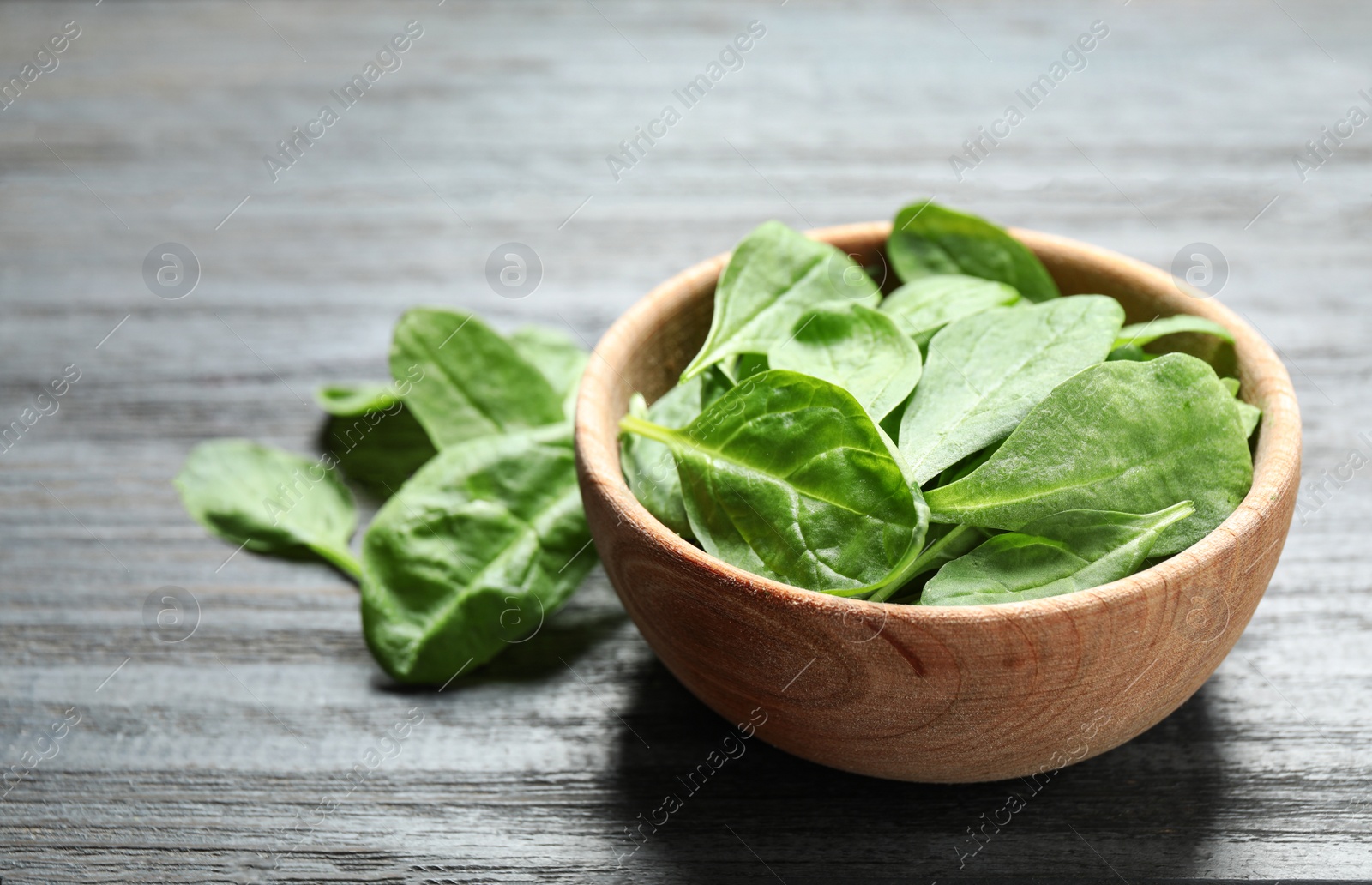 Photo of Fresh green healthy spinach on dark wooden table. Space for text