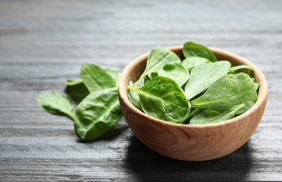 Photo of Fresh green healthy spinach on dark wooden table. Space for text