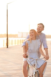 Photo of Happy couple riding bicycle outdoors on summer day