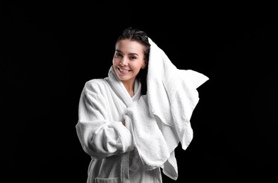 Photo of Pretty woman drying hair with towel after washing on black background