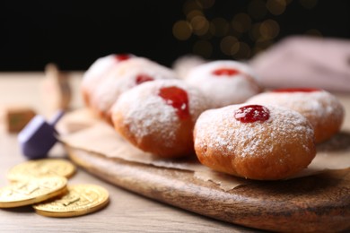 Photo of Hanukkah donuts with jelly and powdered sugar on wooden table, closeup