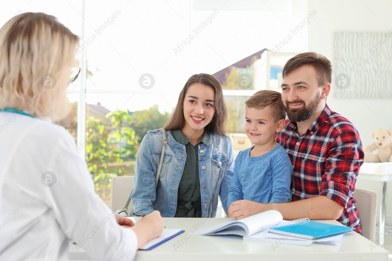 Photo of Little boy with parents visiting children's doctor in hospital