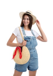 Beautiful young woman with stylish straw bag on white background