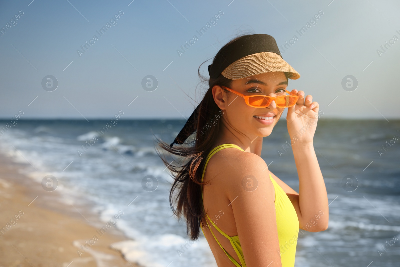 Photo of Beautiful young woman with bright sunglasses on beach