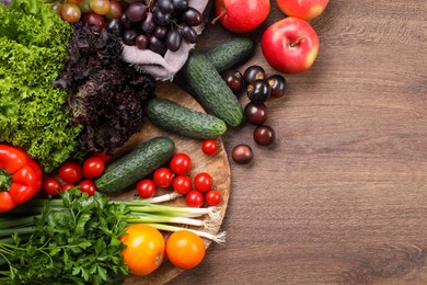 Photo of Different fresh ripe vegetables and fruits on wooden table, flat lay. Space for text