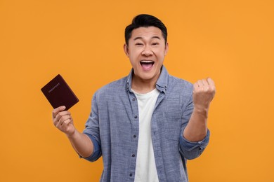 Immigration. Excited man with passport on orange background
