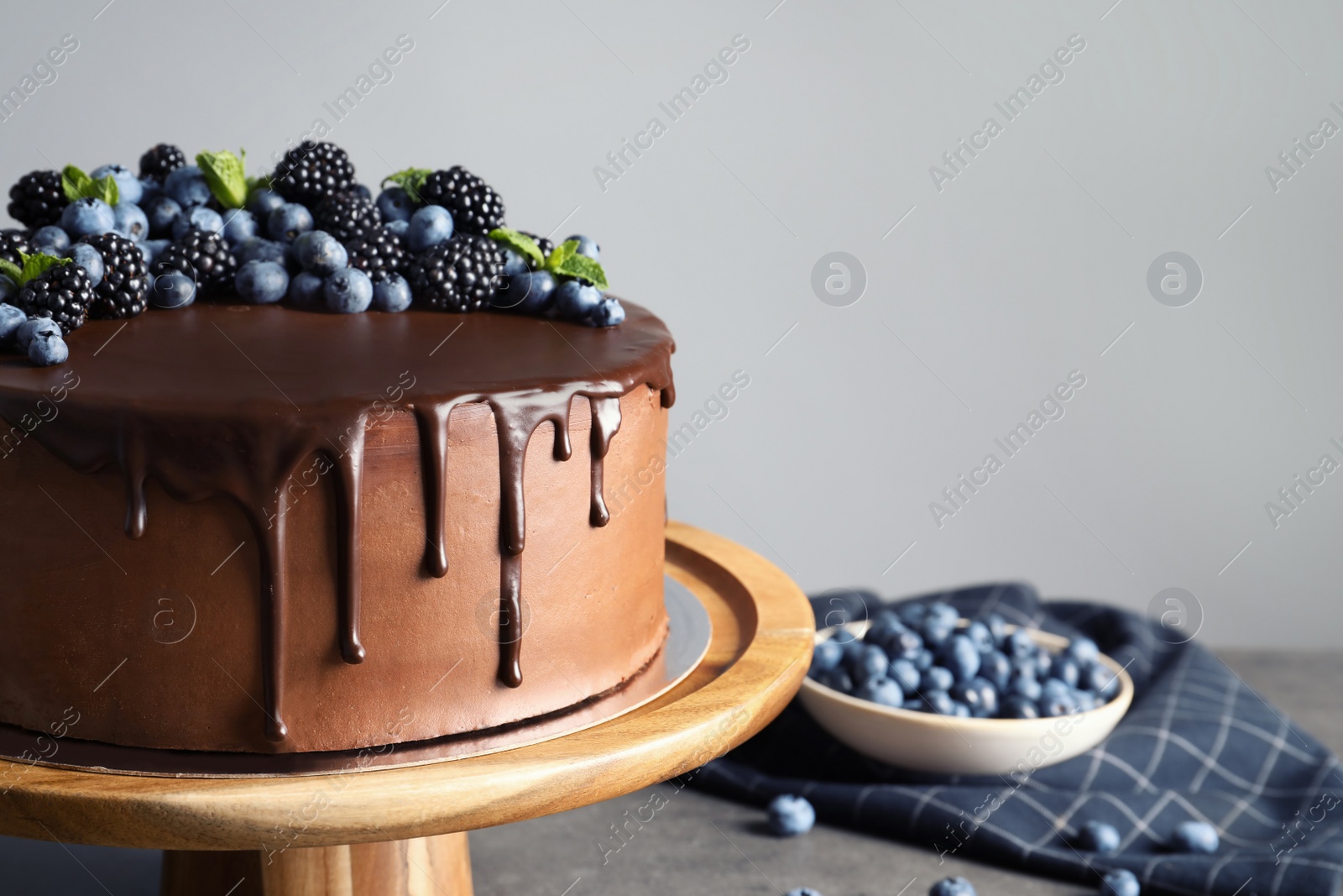 Photo of Fresh delicious homemade chocolate cake with berries on table against gray background. Space for text