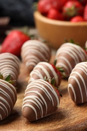 Photo of Delicious chocolate covered strawberries on wooden board, closeup