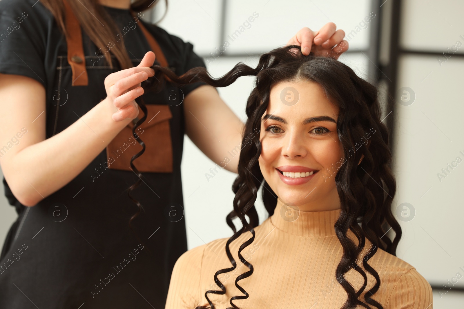 Photo of Hair styling. Professional hairdresser working with smiling client indoors, closeup