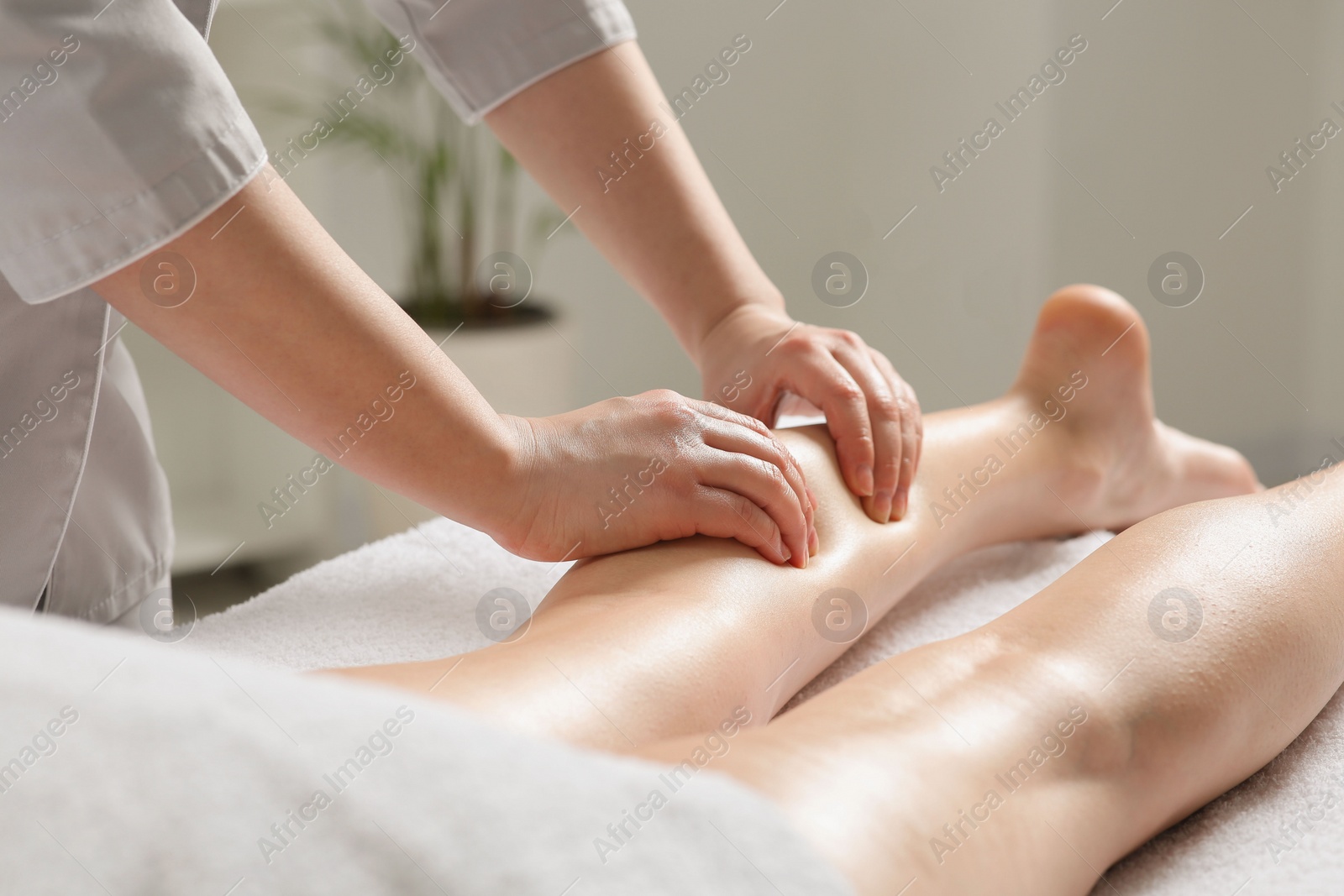 Photo of Woman receiving leg massage in spa salon, closeup