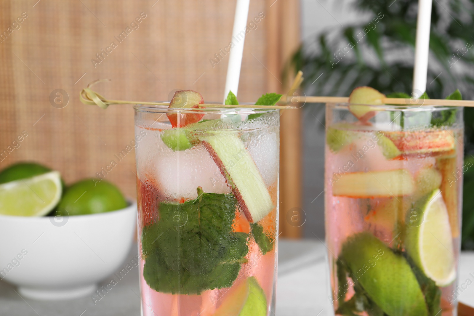 Photo of Tasty rhubarb cocktail with lime indoors, closeup