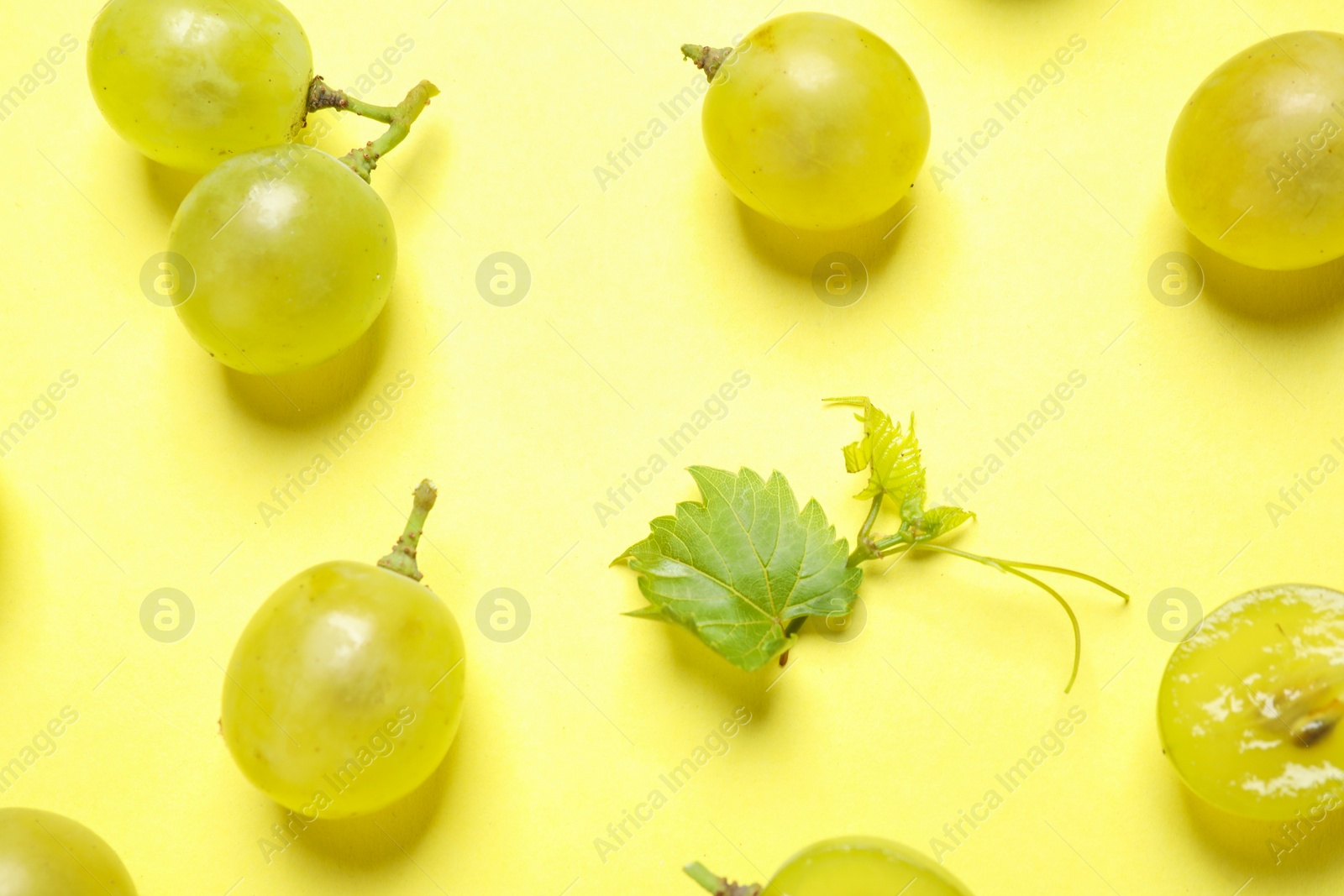 Photo of Flat lay composition with fresh ripe juicy grapes on yellow background