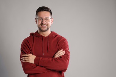 Photo of Portrait of happy man in stylish glasses on light grey background. Space for text
