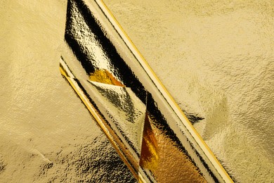 Photo of Edible gold leaf sheets as background, top view