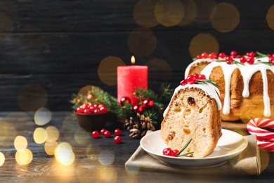 Composition with piece of traditional homemade Christmas cake on black wooden table. Space for text