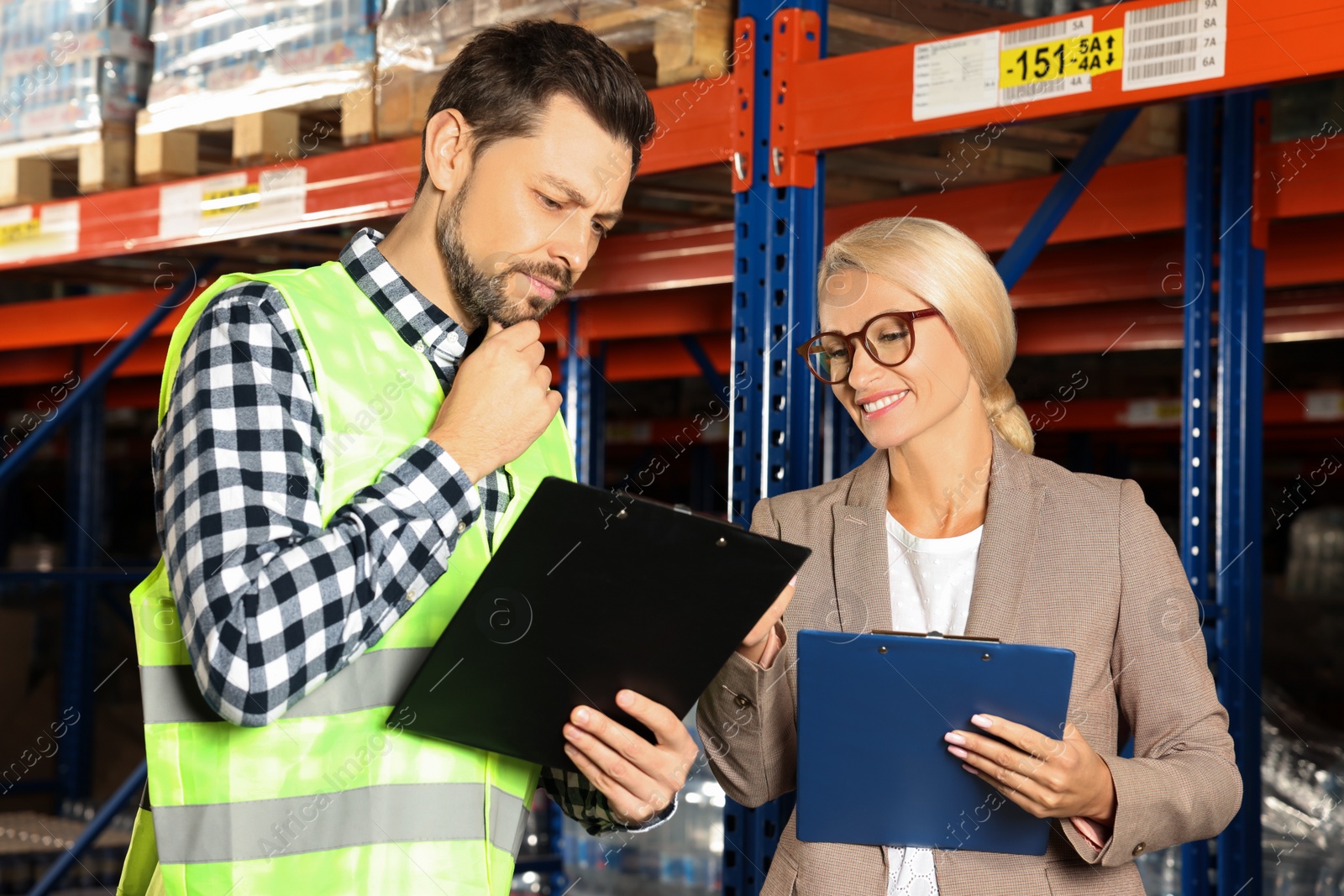 Photo of Manager and worker in warehouse with lots of products