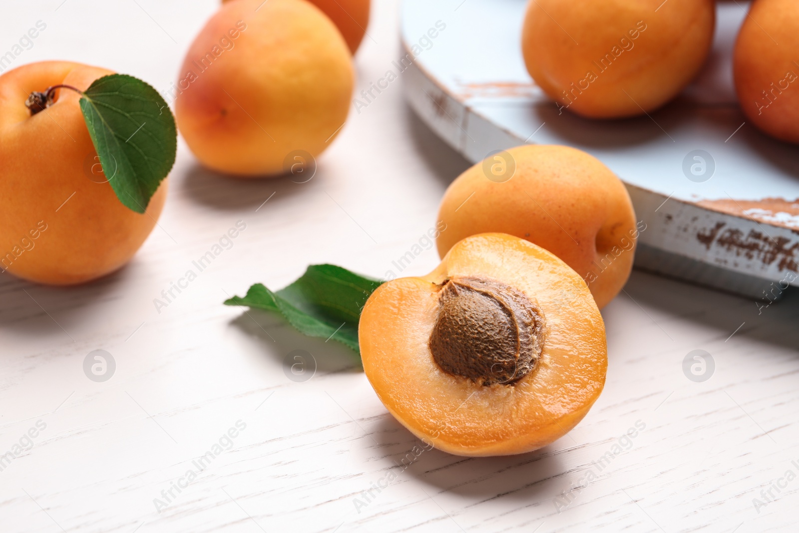 Photo of Delicious ripe sweet apricots on white wooden table, closeup view