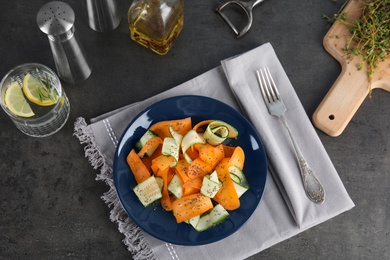 Plate with tasty carrot salad on table, top view