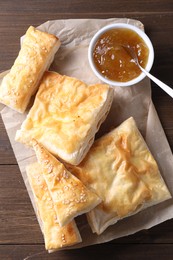 Delicious puff pastry served on wooden table, top view
