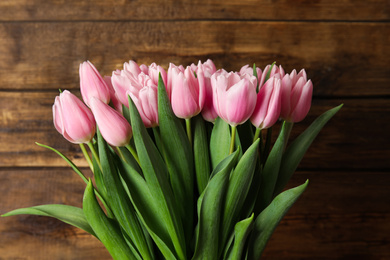 Photo of Beautiful pink spring tulips on wooden background