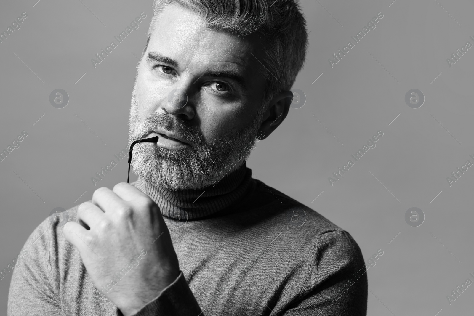 Photo of Portrait of handsome man on grey background. Black and white effect