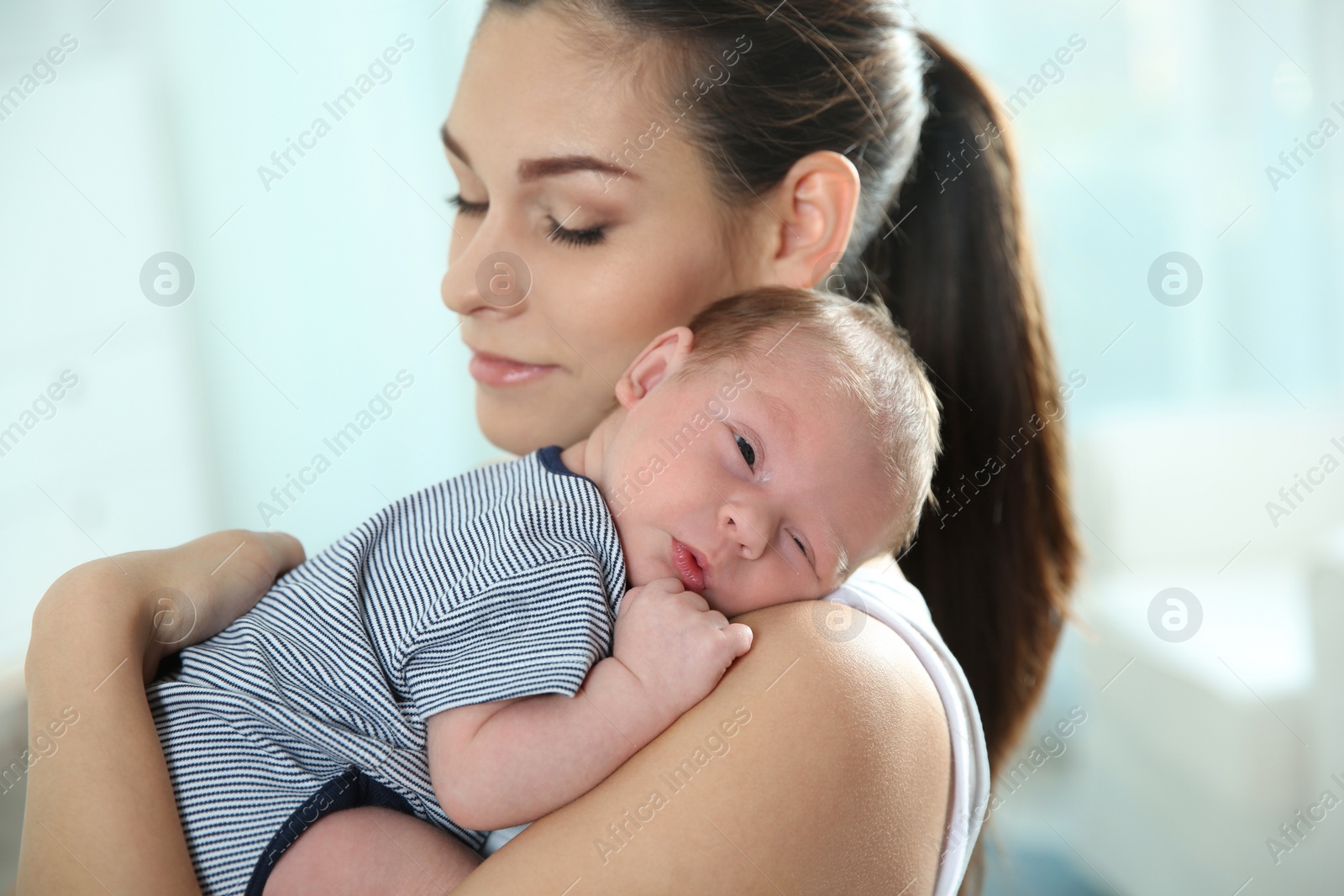 Photo of Young woman with her newborn baby at home