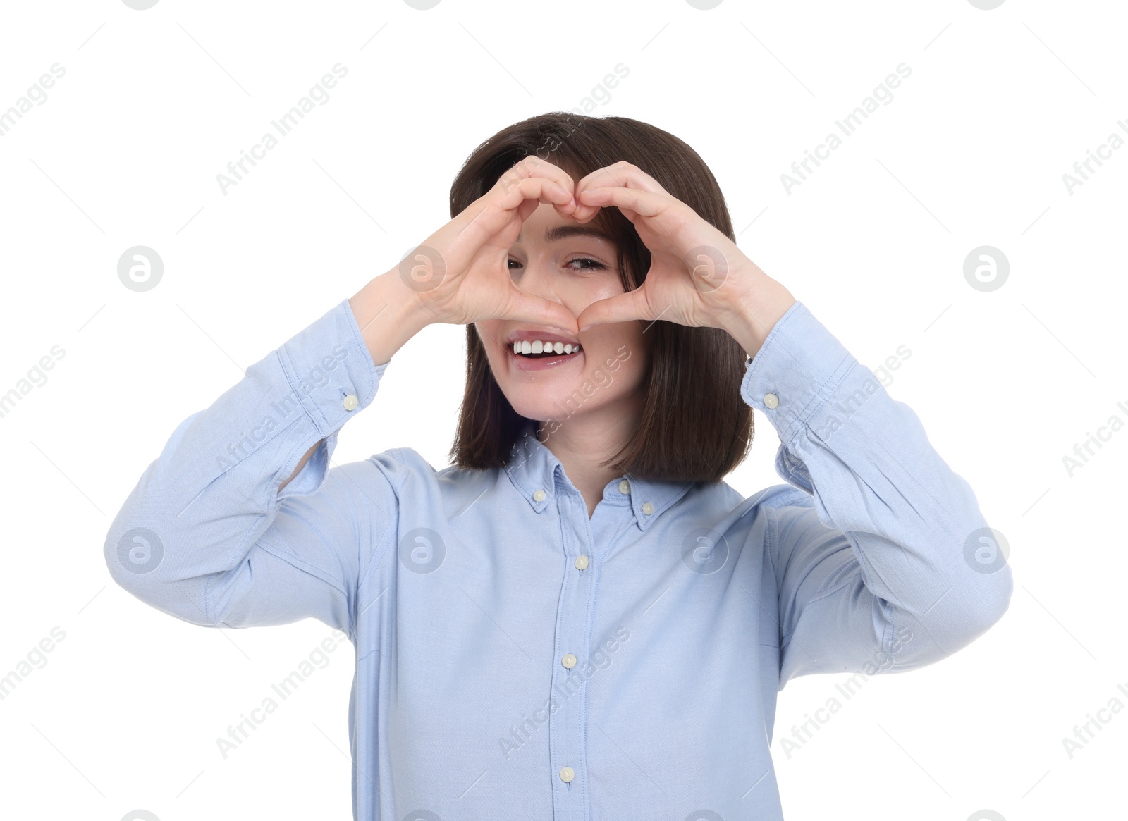 Photo of Happy woman looking through folded in shape of heart hands on white background