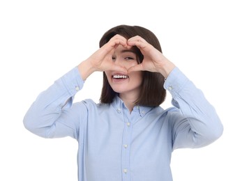 Happy woman looking through folded in shape of heart hands on white background