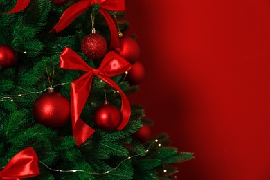 Decorated Christmas tree on red background, closeup. Space for text