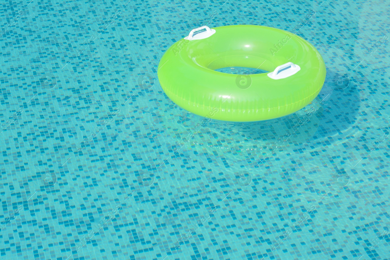 Photo of Light green inflatable ring floating in swimming pool. space for text
