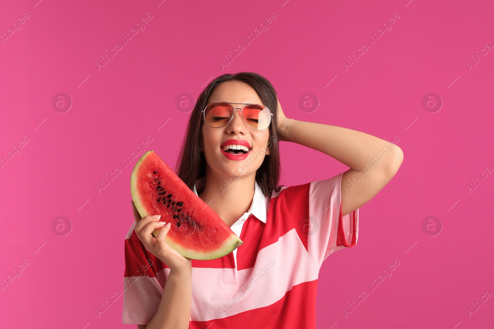 Photo of Beautiful young woman posing with watermelon on color background