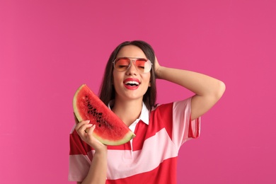 Beautiful young woman posing with watermelon on color background