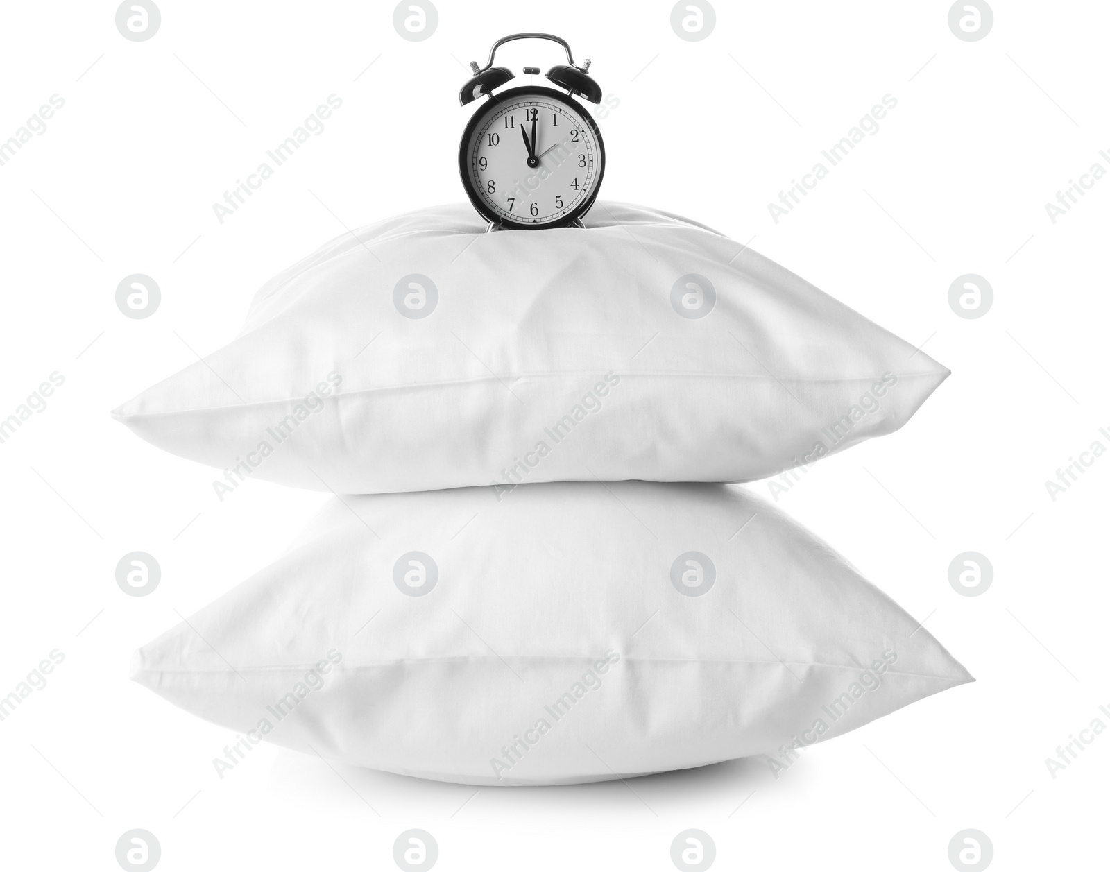 Photo of Soft pillows and alarm clock on white background